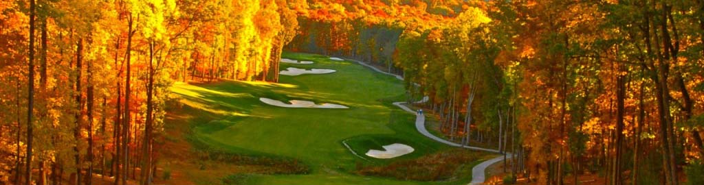 A long shot of the course blanketed by vibrant Autumn colored trees.