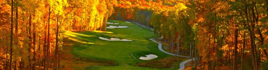 A long shot of the course blanketed by vibrant Autumn colored trees.